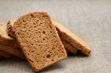 Whole grain rye bread slices on rustic linen cloth