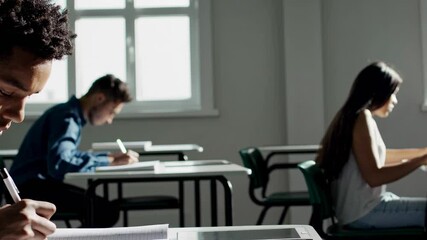 Focused Student Writing During Exam in Classroom – Education and Learning Concept