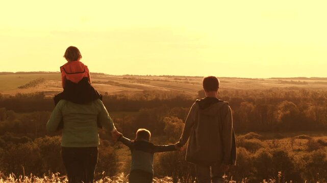 family walks park with children. happy childhood concept. teamwork. child son holding parents hand. rural landscape with people dawn. happy family concept. cheerful life mother father children