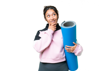Young sport woman going to yoga classes while holding a mat over isolated chroma key background and looking up