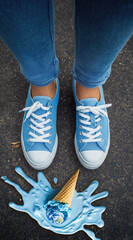 A pair of blue sustainable sneakers stands over a melting ice cream cone on asphalt, symbolizing the urgent need for climate action and youth engagement in eco activism
