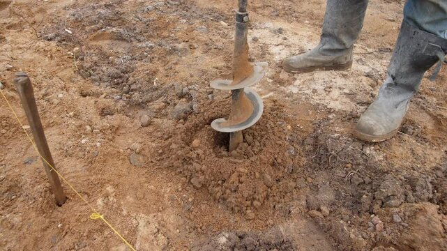 A detailed closeup view of an auger actively being utilized for soil excavation in preparation for construction