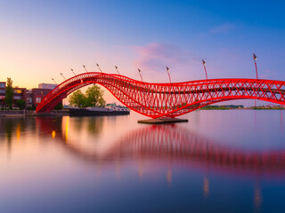 The Python Bridge, Amsterdam, the Netherlands. The bridge on the blue sky background during the blue hour. Dutch canals. Photo for background, wallpaper, postcards.