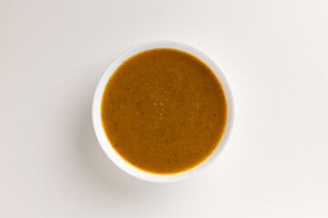 A top view of a round white bowl filled with summer vegetable purée, set against a white background. Simple, clean design, perfect for food styling, product mockups, or promotional use.