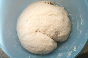 Bread dough ready to rise. Top vie of raw kneaded yeast bread resting in dish. Ready for first rise. Traditional Swiss butter bread recipe called Zopf or Butterzopf. Or challah bread. Selective focus.