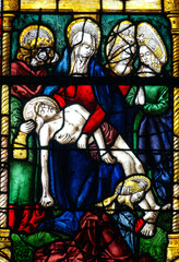 Fototapeta premium Stained glass (19th century) of The Pietà. Blessed Virgin Mary holding Jesus Christ body after his Deposition from the Cross..