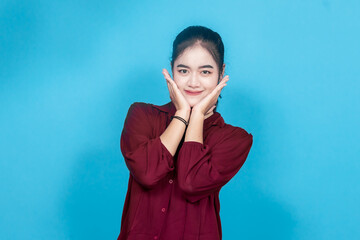 A young woman in a casual maroon outfit conveys emotion through her facial expression and body...