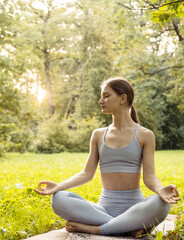 Portrait of a young woman doing yoga in the garden for a workout. Concept of lifestyle fitness and...