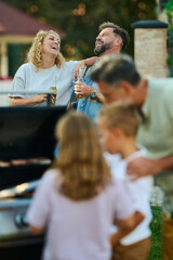Happy family having barbecue party in backyard
