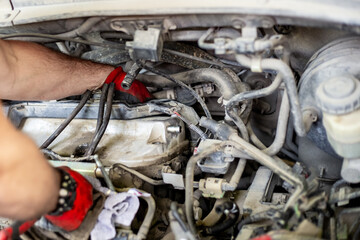 Car repair. Mechanic removes electronic equipment from the top of the timing belt valve cover
