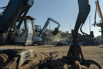 Large excavators work on scrap metal