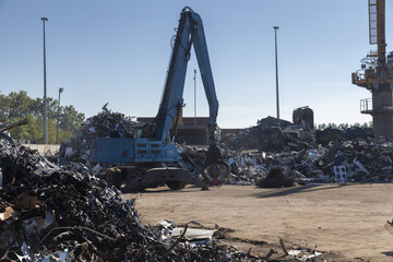 Large excavators work on scrap metal