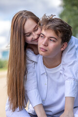 Close-up portrait of couple in love. Young woman and men walking and having fun in park on warm summer day. Vertical photo. High quality photo