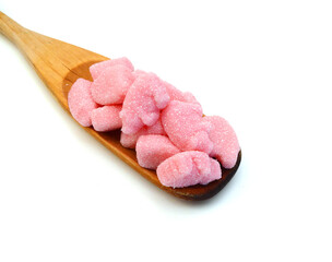 Gummy pigs shaped cutter and wooden spoon on white background