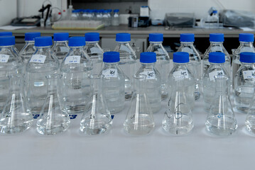 Laboratory equipment. Laboratory storage bottles with blue polypropylene cap on white table.