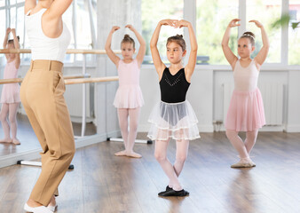 Little girls are learning various dance and ballet movements in the studio © JackF
