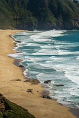 Turquoise waves and sandy beach with a tropical island view under a sunny sky in Hawaii