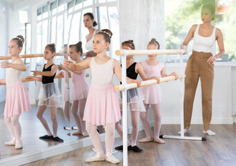 Lesson for little ballerinas - girls learn to dance ballet in a choreographic class © JackF
