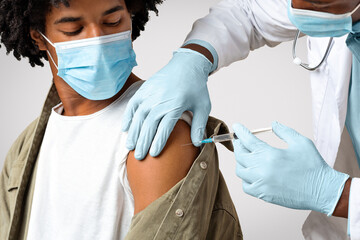 Vaccination Concept. Doctor Giving Shot Or Vaccine Injection To Black Male Patient, Inserting...