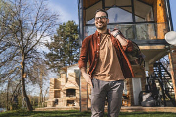 Fototapeta premium Portrait of one man happy caucasian male with travel bag at his house