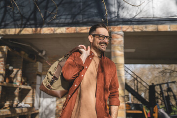 Portrait of one man happy caucasian male with travel bag at his house