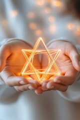 Woman's hands gently cradling a glowing, six-pointed star. Warm, ethereal light.