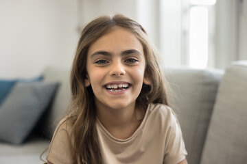 Head shot portrait laughing beautiful little 6s girl, smile, revealing teeth, looking at camera, advertising professional orthodontics and dental clinic services for kids. Happy carefree childhood