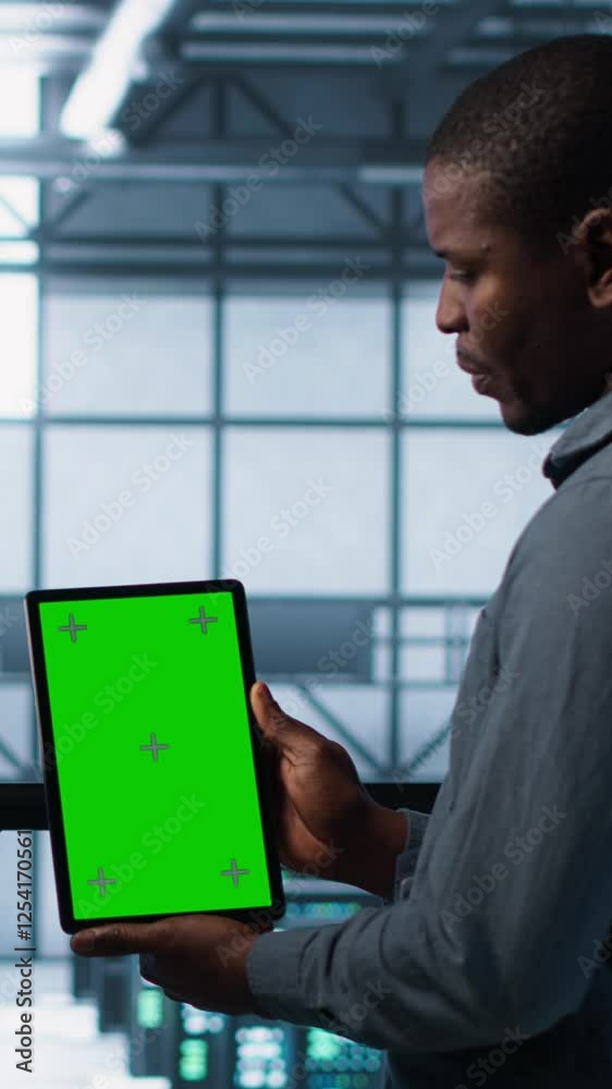 Poster vertical video software developers in data center using mockup tablet, observing performance analyti