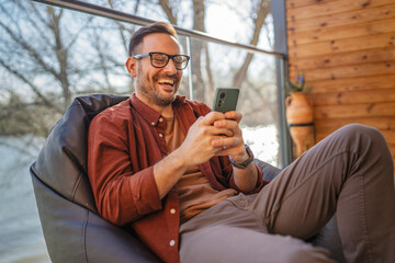 One adult man at home use smart phone app browse internet or send sms