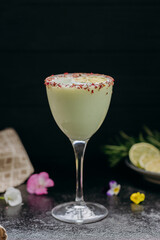 Elegant citrus cocktail in tall glass with floral garnish and dried lime slice, perfect for summer