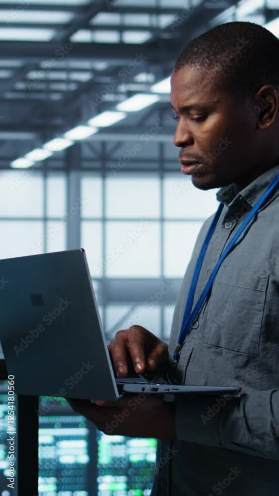 Poster vertical video team of technicians working in server farm, using laptops to analyze data. teamworkin