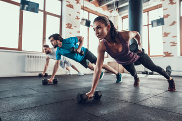 Athletes On The Floor. Dumbbell Lift With One Hand