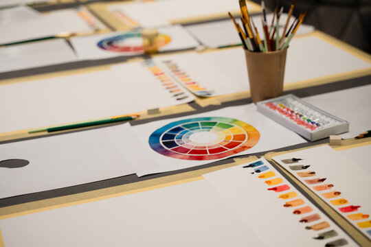 Organizing art workspace for artists experiments with colors. Art palette with watercolor paints and paintbrushes prepared for art masterclass.