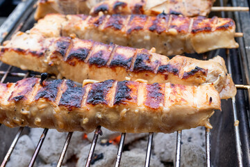 Chicken skewers over charcoal