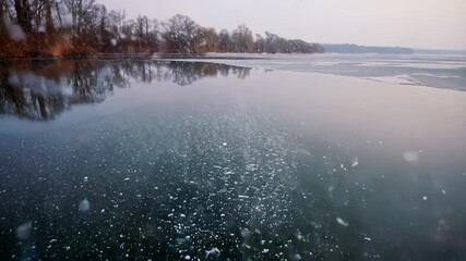 Early morning light illuminates the glacial lake as ice cracks and breaks, sending shards splashing into the water. The tranquil atmosphere enhances the natural beauty of the scene. - Powered by Adobe