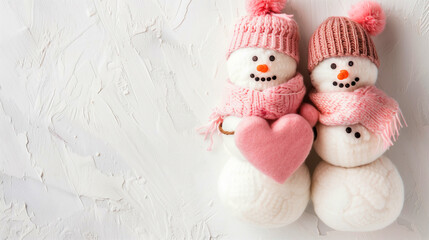 Cozy Snowmen with Pink Heart, Romantic Winter Theme. Two plush-textured snowmen with pink hats and scarves embrace a soft pink heart, symbolizing love and warmth. Blank text area.