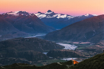 A snowy mountain valley at sunrise.