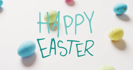 Fototapeta premium Image of happy easter text over colourful eggs on white background