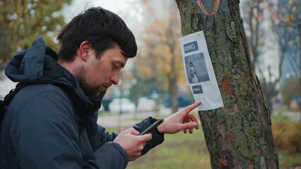 Search for missing pets. Lost dog man found her and calls the owner on an advertisement on a tree in the park. The guy dials the number from the poster about the loss of dog. Lost husky please find