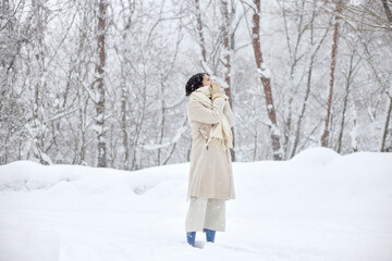 冬の雪国に佇むマフラーを巻いた日本人女性