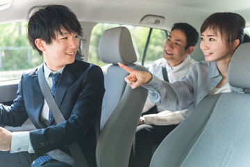 自動車購入・査定・買取にきた顧客を接客するセールスマンの若いアジア人男性
