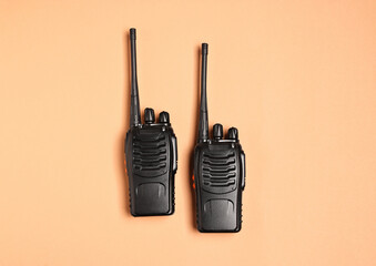 Walkie talkies on beige background, top view