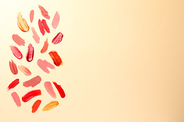 Samples of different lip products on beige background, top view. Space for text