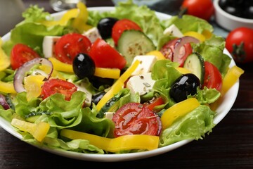 Delicious fresh Greek salad on wooden table, closeup