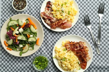Tasty brunch. Delicious scrambled eggs, bacon and salad served on table, flat lay