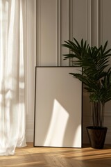 Minimalist interior featuring blank canvas and potted plant in sunlight
