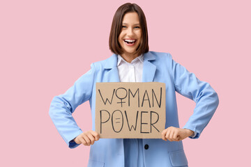 Beautiful young woman holding WOMAN POWER sign on pink background. Women's history month