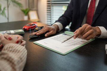 a car salesperson is explaining the details of a car purchase contract to the buyer before signing the sales contract, showroom, dealer, car contract, sining a car purchase contract