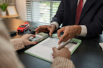 a car salesperson is explaining the details of a car purchase contract to the buyer before signing the sales contract, showroom, dealer, car contract, sining a car purchase contract