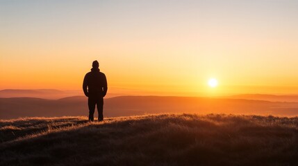Silhouette of person watching sunrise over mountain landscape. Great for inspiration, adventure, and personal achievement themes.